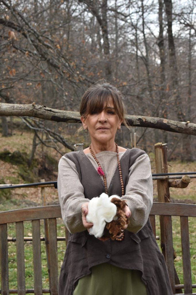 Ana artesana rural sosteniendo lana merina natural en Casillas, Ávila